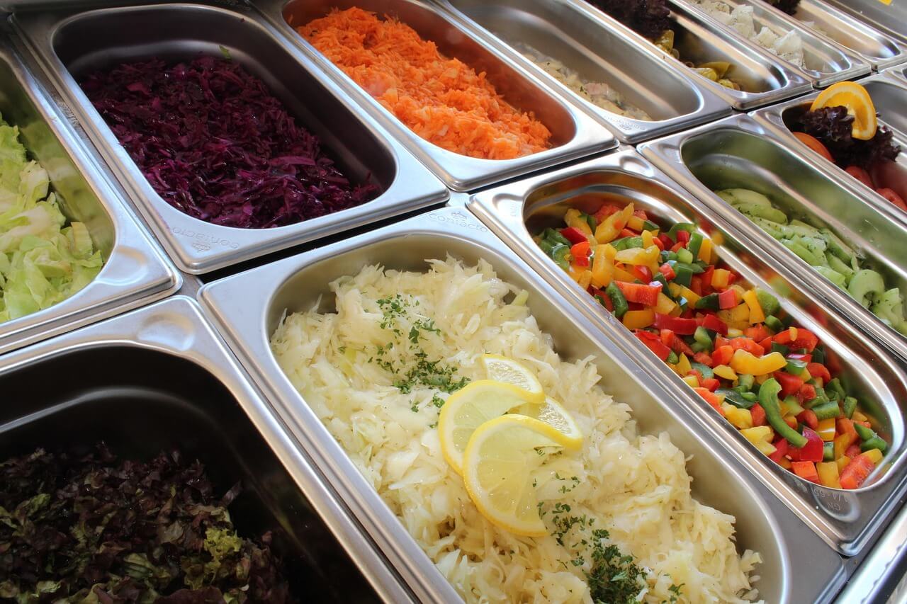 Professional corporate event buffet with diverse gourmet options and professional staff